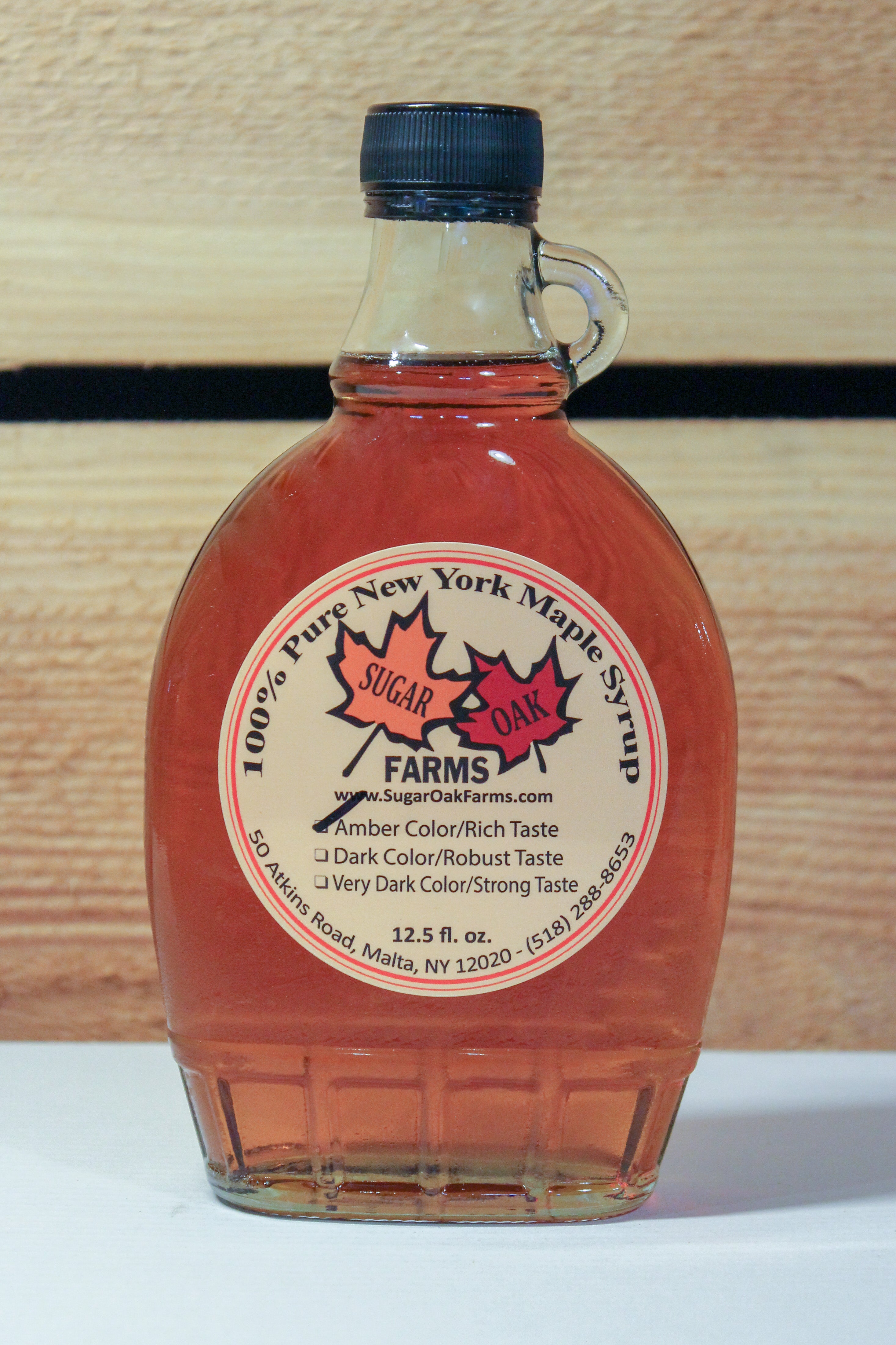 A glass 12.5 fl. oz. bottle of amber syrup.