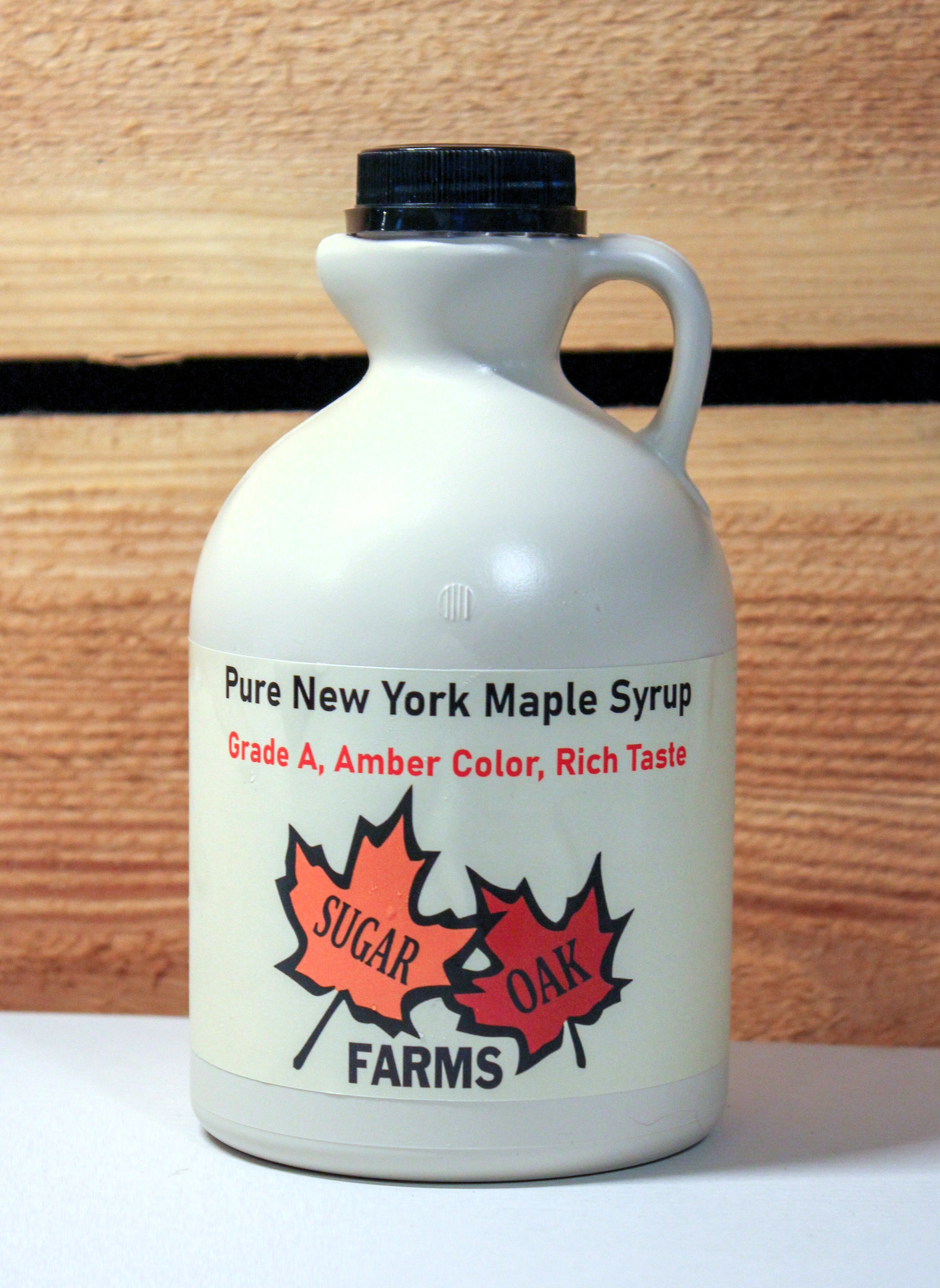 A plastic quart of amber syrup.