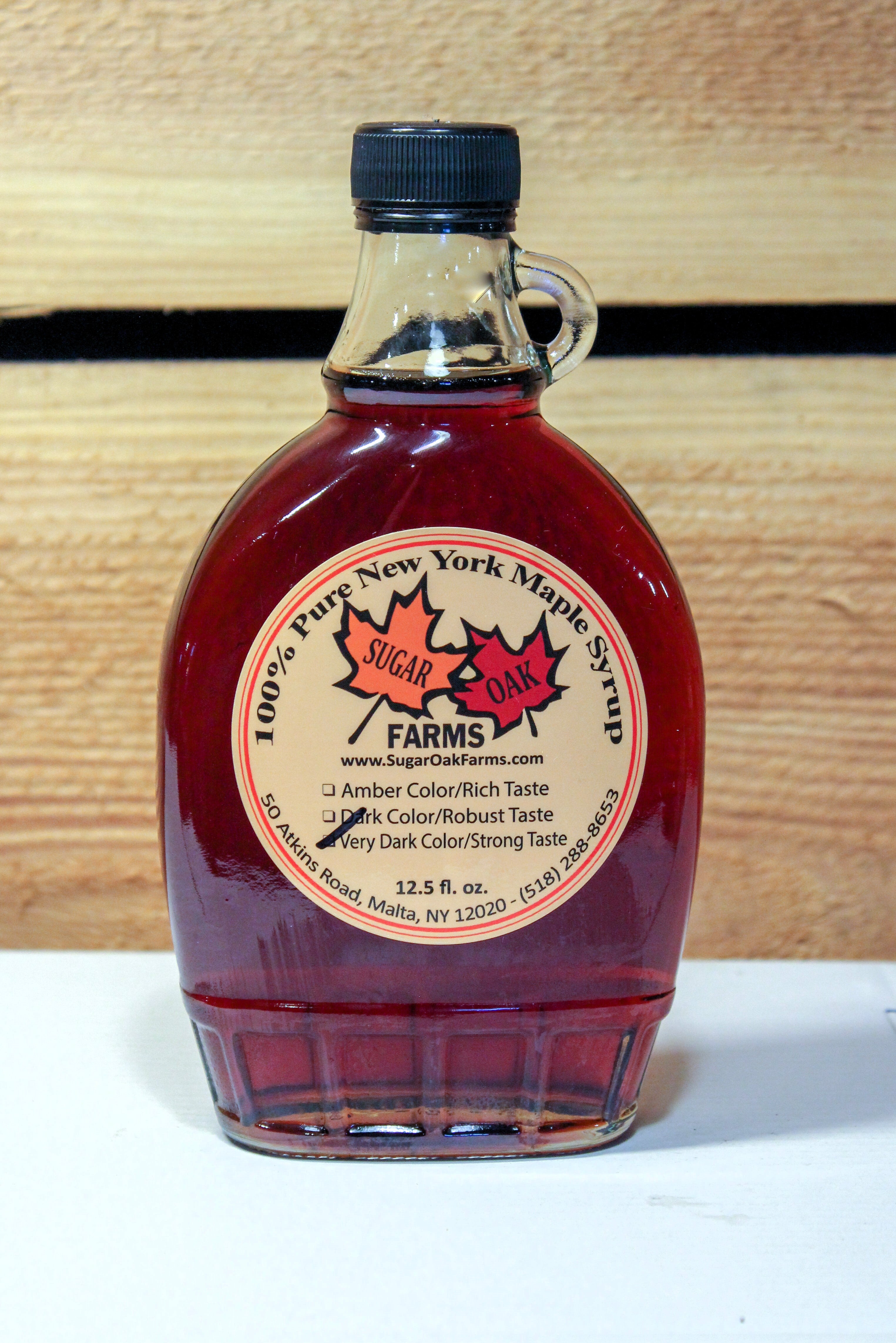 A 12.5 fl. oz. glass bottle of very dark syrup.